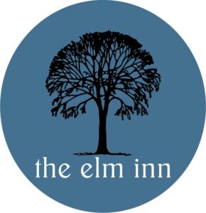 round blue logo with a black elm tree and the words the elm inn in white underneath the tree